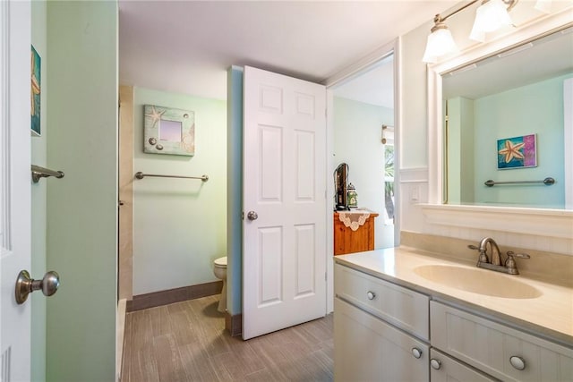 bathroom featuring vanity, toilet, and wood finished floors