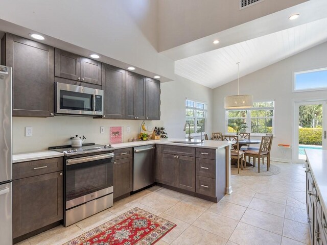 1880 Cobia Dr, Vero Beach, FL 32960 - kitchen with appliances with stainless steel finishes, a sink, dark brown cabinets, light countertops, and healthy amount of natural light