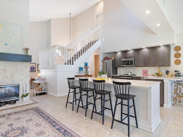 1880 Cobia Dr, Vero Beach, FL 32960 - kitchen featuring stainless steel appliances, a high ceiling, a kitchen breakfast bar, light countertops, and baseboards