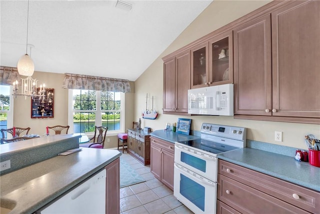 kitchen with a notable chandelier, pendant lighting, vaulted ceiling, white appliances, and light tile patterned floors