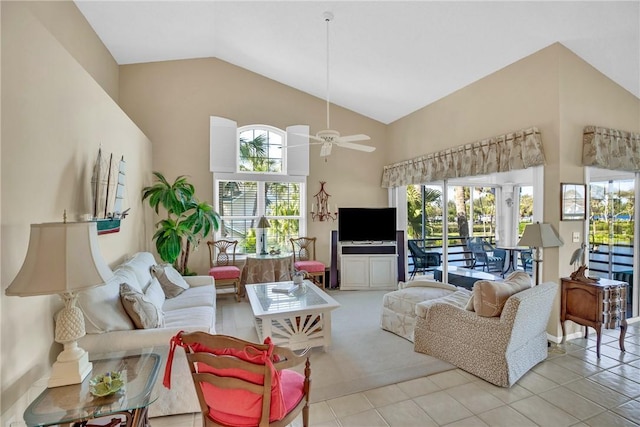 living room with ceiling fan, light tile patterned flooring, plenty of natural light, and vaulted ceiling