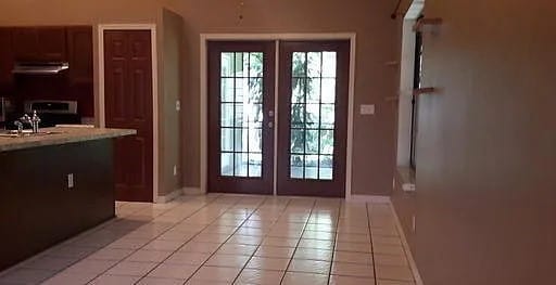 entryway with french doors, light tile patterned floors, and sink