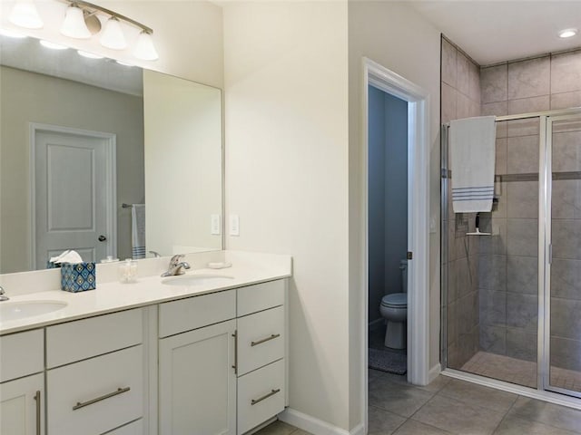 bathroom featuring a shower with door, tile patterned floors, vanity, and toilet