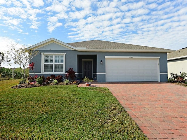 single story home with a garage, decorative driveway, a front lawn, and stucco siding