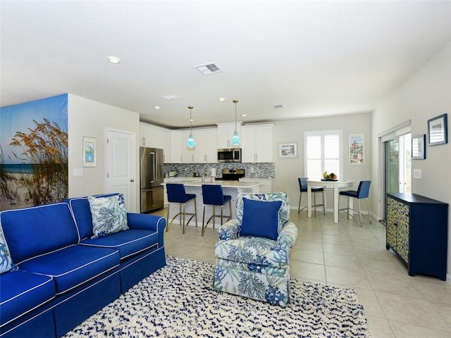 living area featuring light tile patterned floors, baseboards, visible vents, and recessed lighting