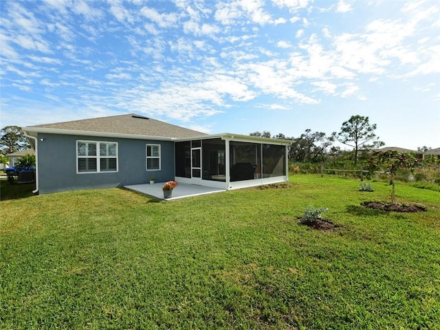 rear view of property featuring a patio, a yard, and a sunroom