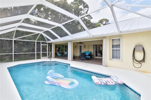 view of swimming pool with outdoor lounge area, a patio, ceiling fan, and a lanai