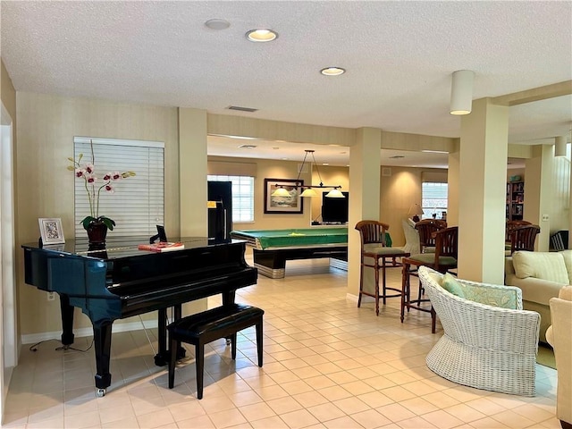 misc room with light tile patterned floors, a textured ceiling, and pool table