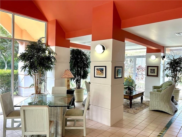 dining room featuring lofted ceiling and light tile patterned flooring