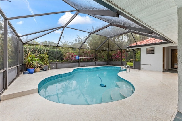 view of swimming pool featuring a patio and glass enclosure