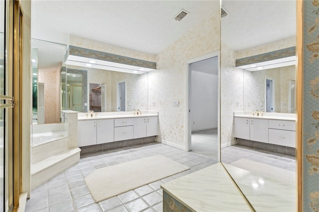 bathroom featuring vanity, a bath, tile patterned flooring, and a textured ceiling