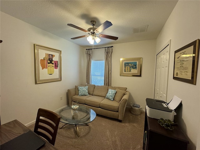 carpeted living room featuring a textured ceiling and ceiling fan