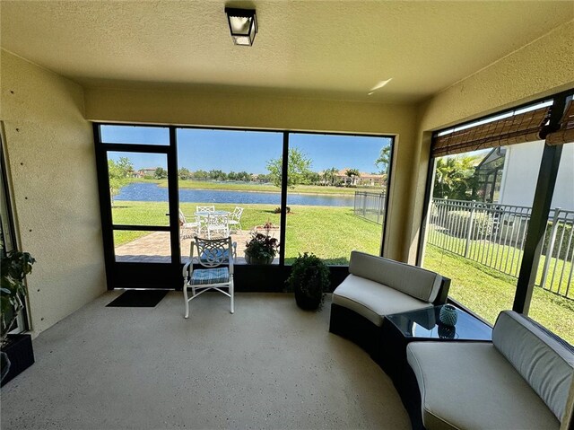 sunroom featuring a water view