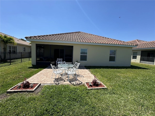 rear view of house with a lawn and a patio