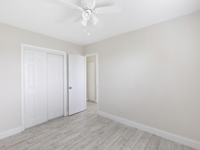 unfurnished bedroom with ceiling fan, a closet, and light hardwood / wood-style flooring