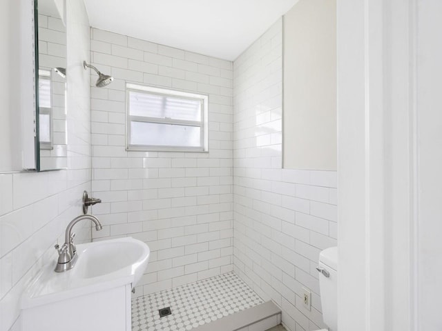 bathroom with toilet, tile walls, and a tile shower