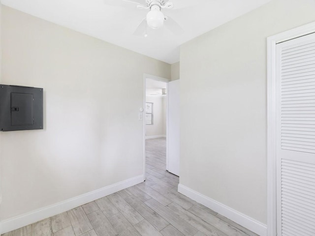 spare room with ceiling fan, light hardwood / wood-style flooring, and electric panel