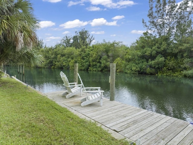 view of dock with a yard and a water view