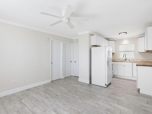 kitchen with wood counters, ceiling fan, white refrigerator with ice dispenser, white cabinets, and sink