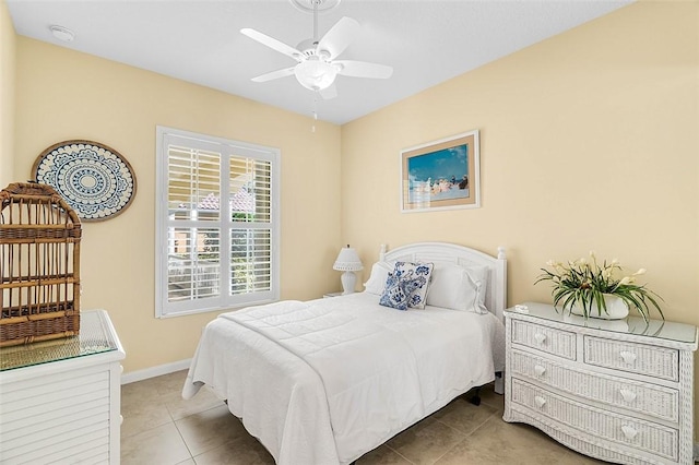 tiled bedroom featuring a ceiling fan and baseboards