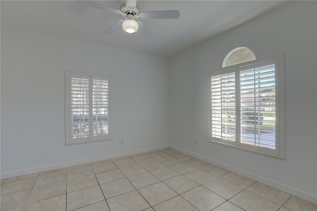 tiled spare room featuring plenty of natural light and ceiling fan