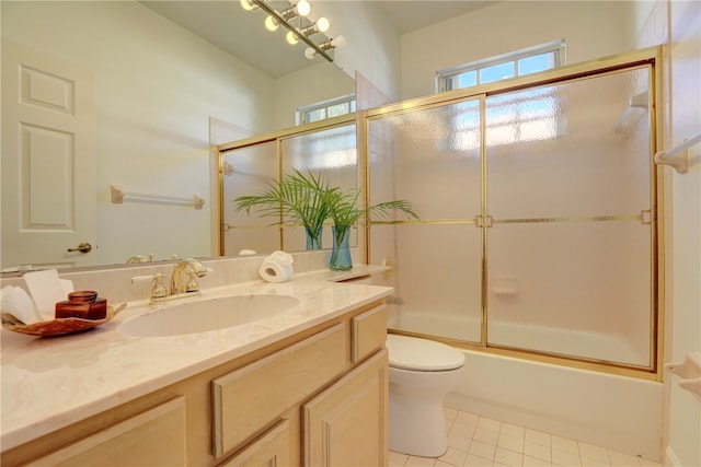 full bathroom with tile patterned flooring, vanity, toilet, and bath / shower combo with glass door