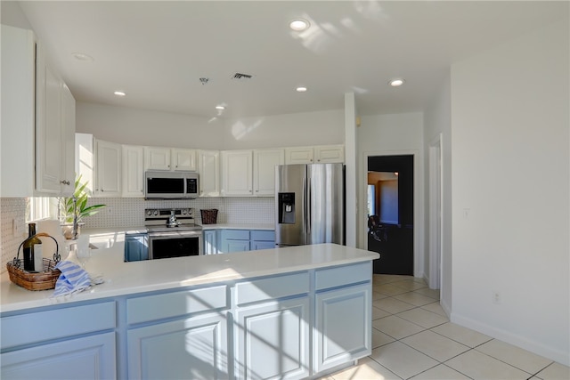 kitchen with kitchen peninsula, white cabinetry, light tile patterned floors, and appliances with stainless steel finishes