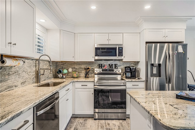 kitchen with white cabinets, sink, ornamental molding, and stainless steel appliances