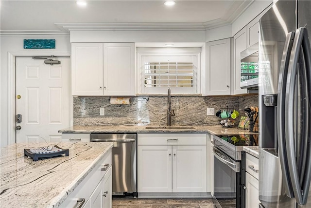 1441 Ocean Dr Unit 207, Vero Beach, FL 32963 - kitchen featuring appliances with stainless steel finishes, crown molding, a sink, white cabinetry, and light stone countertops