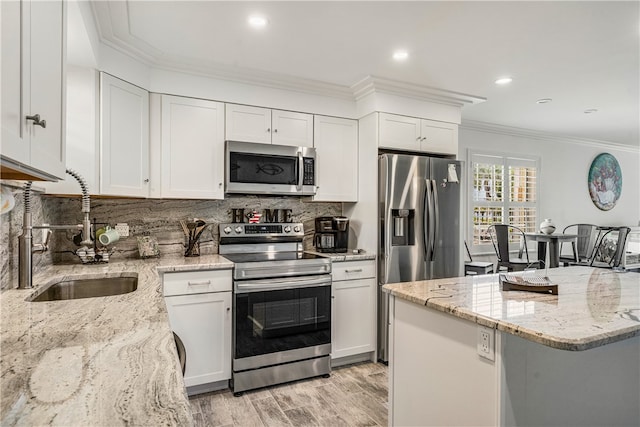 kitchen featuring crown molding, sink, light stone countertops, white cabinetry, and stainless steel appliances