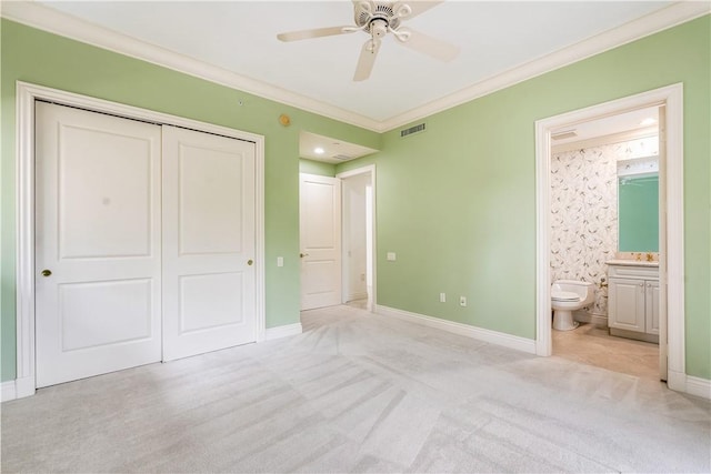 unfurnished bedroom featuring baseboards, visible vents, ornamental molding, a closet, and light colored carpet