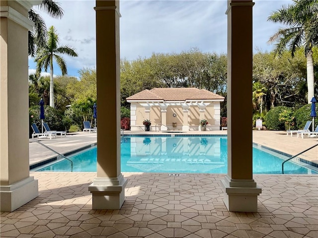 pool featuring an outbuilding and a patio area