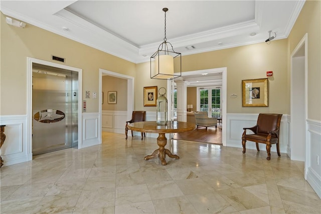 dining area featuring visible vents, elevator, decorative columns, a raised ceiling, and a decorative wall