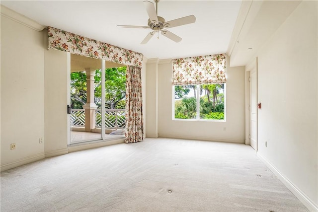 carpeted spare room with baseboards, a healthy amount of sunlight, and ceiling fan