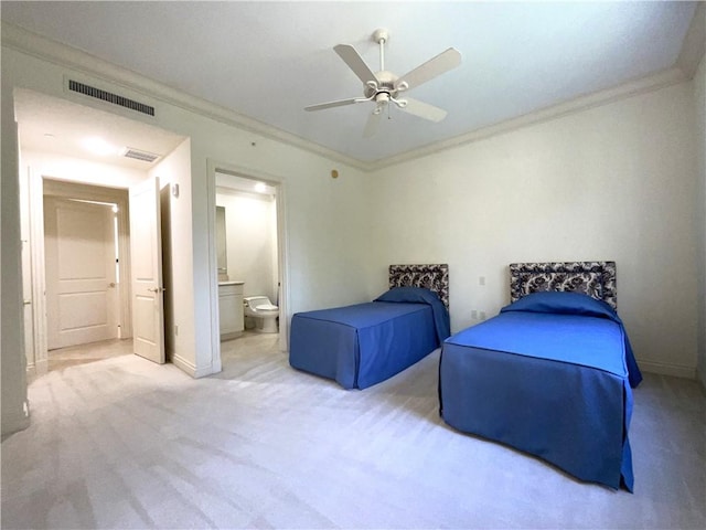 carpeted bedroom featuring ensuite bath, crown molding, baseboards, and visible vents