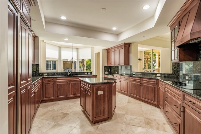 kitchen featuring premium range hood, a center island, a peninsula, black electric cooktop, and a raised ceiling