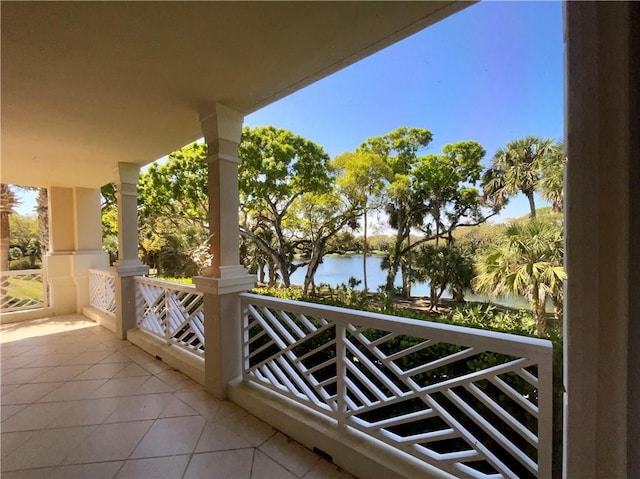 balcony with covered porch and a water view