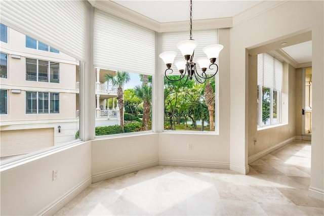 unfurnished dining area with a chandelier, crown molding, and baseboards