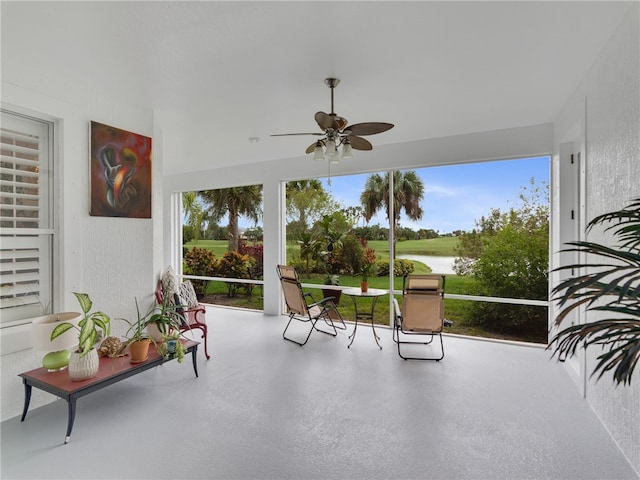 sunroom featuring ceiling fan, plenty of natural light, and a water view