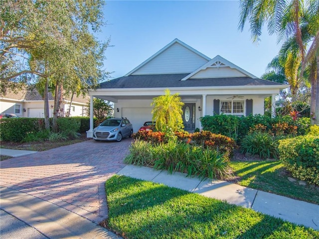 view of front of house featuring decorative driveway, an attached garage, and stucco siding