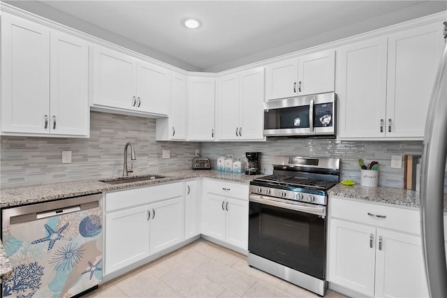 kitchen featuring white cabinetry, sink, light stone countertops, backsplash, and appliances with stainless steel finishes