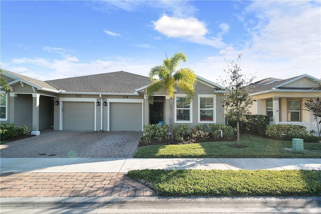 single story home featuring a garage and a front lawn