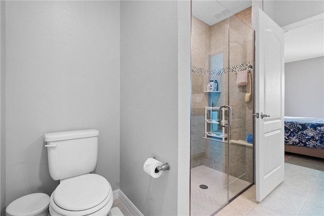 bathroom featuring tile patterned floors, a shower with door, and toilet