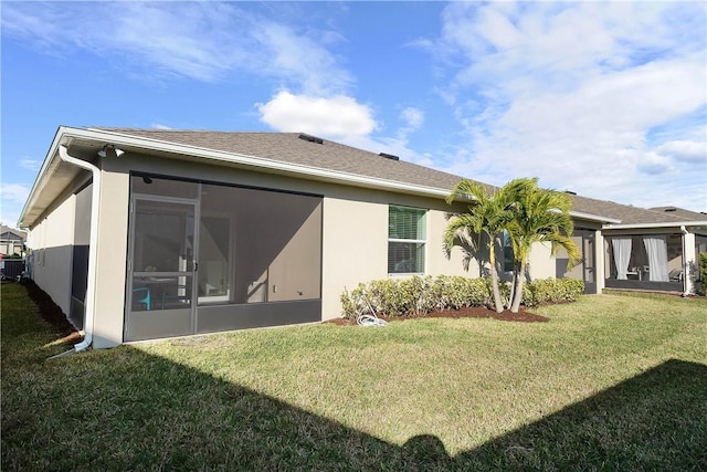 rear view of house featuring a sunroom and a yard