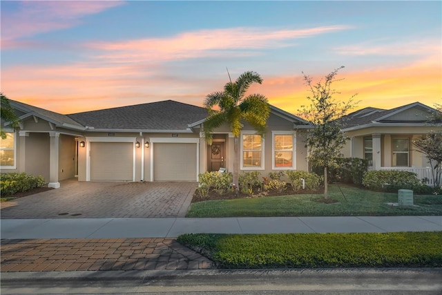 ranch-style house featuring a garage and a yard