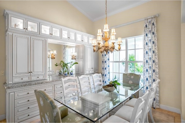 dining space featuring crown molding, vaulted ceiling, and a notable chandelier