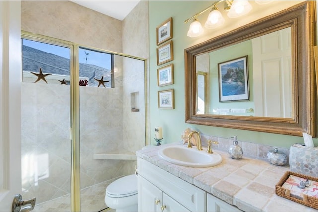 bathroom with vanity, toilet, and a shower with shower door