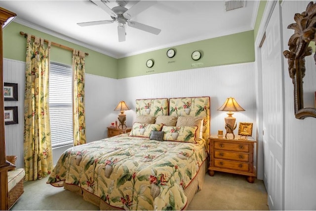 bedroom with crown molding, ceiling fan, a closet, and light colored carpet