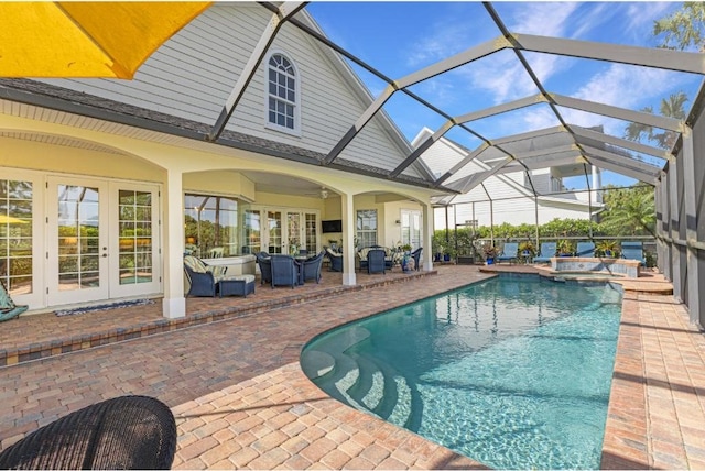 view of swimming pool with a patio area, a lanai, an in ground hot tub, and french doors