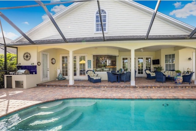 view of swimming pool featuring a lanai, area for grilling, a patio area, and french doors